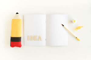 שתי עפרונות על מחברת עם המילה IDEA